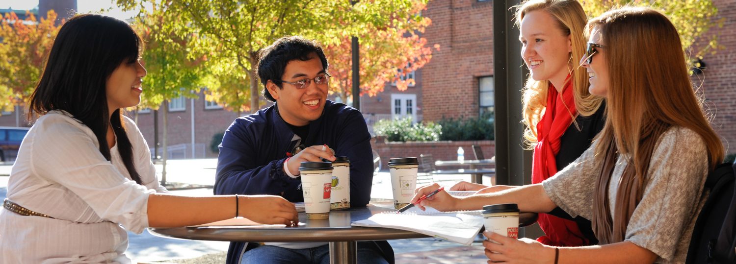 Students share conversation while sitting in front of the Port City Java near SAS Hall. Photo by Marc Hall.