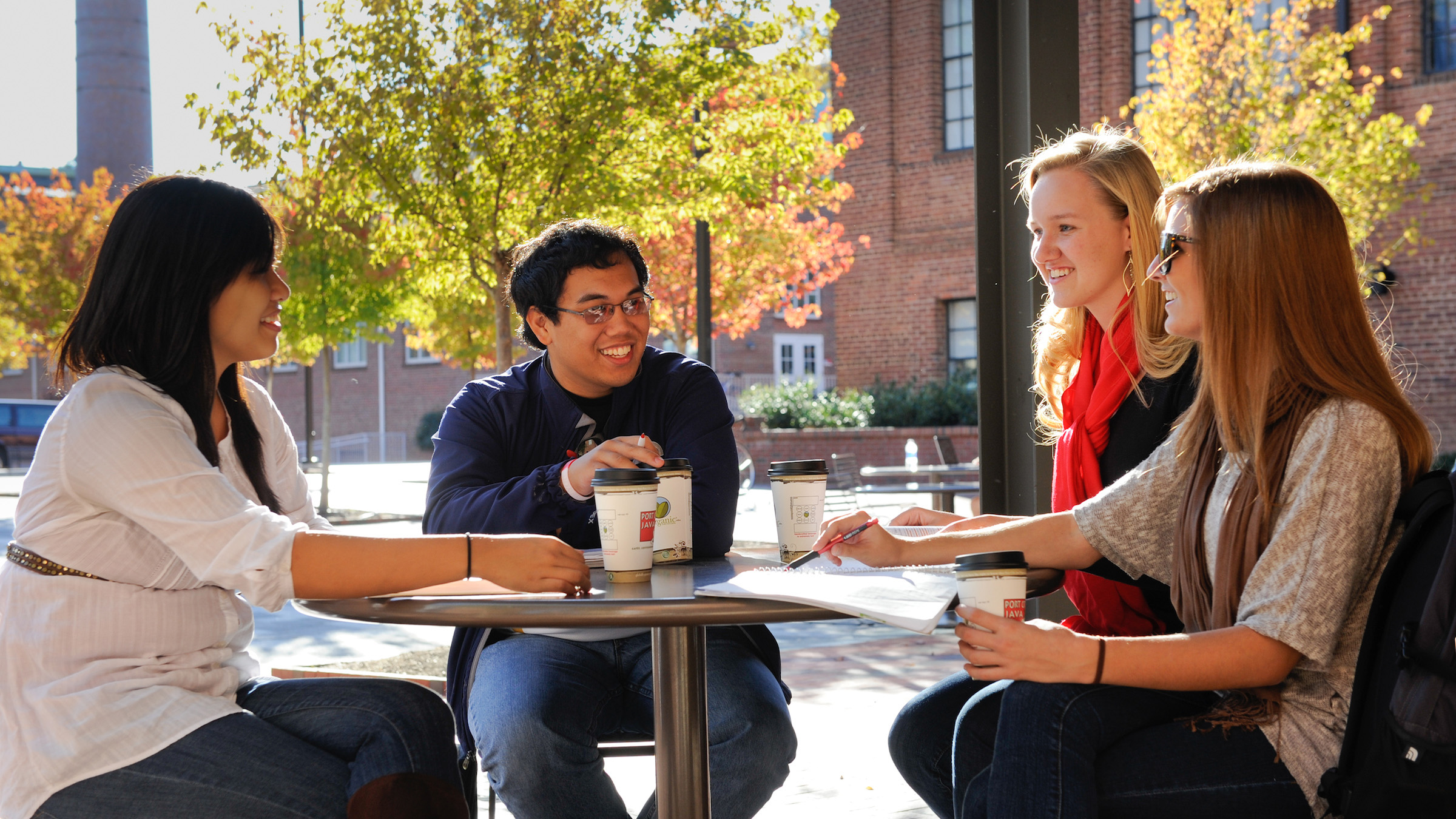 Students share conversation while sitting in front of the Port City Java near SAS Hall. Photo by Marc Hall.