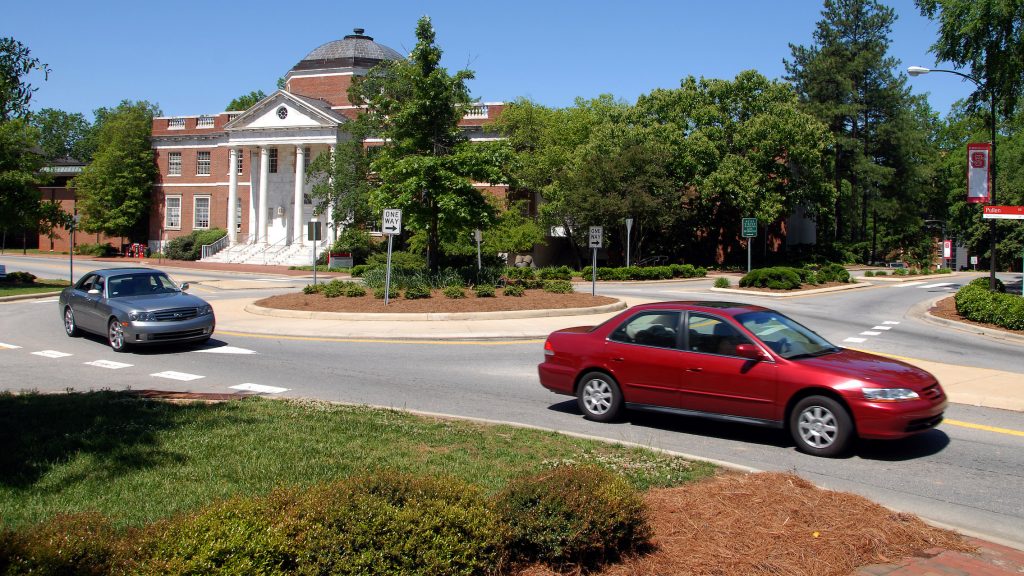 Cars navigate around the traffic circle, past Brooks Hall, on Pullen Road.