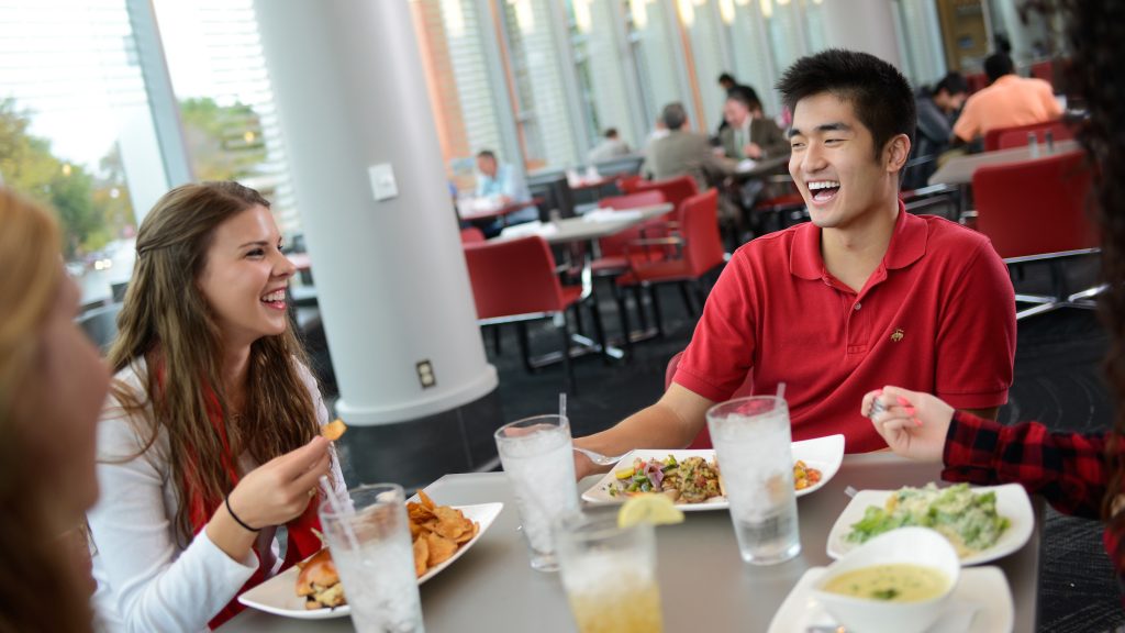 Two students eating and laughing